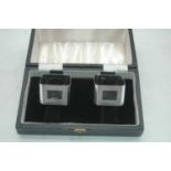 A pair of modern silver napkin rings, each of square shape with engine turned decoration and