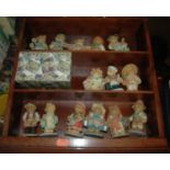 A collection of Cherished Teddies, all housed in a display case Across the Seas with Cherished