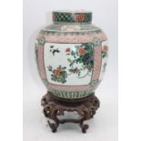 A Chinese famille verte porcelain ginger jar, h.24cm, mounted upon a hardwood stand (a/f)Lid with