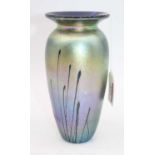A late 20th century iridescent glass vase, having a flared rim to a tapering body, with indistinct