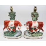 A pair of Staffordshire flatback models of cows, later converted to table lamps, height 34cmFiring
