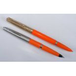 Two Parker fountain pens in orange, one being a 51 with rolled gold cap, the other probably a 45
