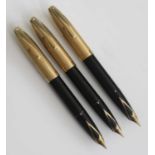 Three Sheaffer PFM V fountain pens, in black with gold trim, having rolled gold caps and 14k gold