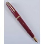 A Parker Duofold fountain pen, in deep red with gold trim, the barrel faintly engraved PARKER