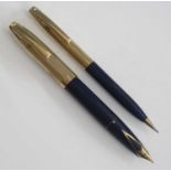 A Sheaffer PFM V fountain pen and pencil set, circa 1960s, in navy blue with gold trim, rolled