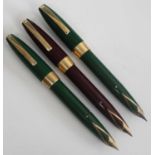 Three Sheaffer PFM fountain pens, being two in dark green and one in burgundy, all with gold trim