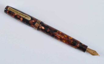 A cased Tibaldi Iride fountain pen, in transparent red celluloid with gold trim, the branded nib