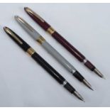 Three Sheaffer Snorkel fountain pens, in grey, black and burgundy, with gold fittings and white dots