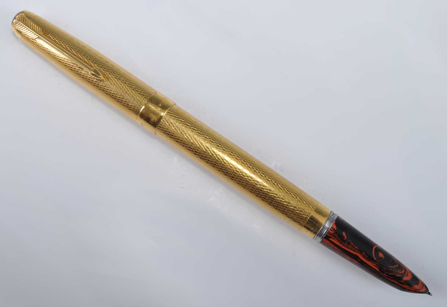 A Parker 51 fountain pen by Ariel Kullock, having red ripple hood and gold barley case, the barrel