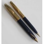 A Sheaffer PFM V fountain pen and pencil set, circa 1960s, in navy blue with gold trim, rolled