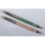 Two Sheaffer Snorkel fountain pens, in buckskin tan (pink) and sage green, with gold and silver