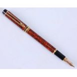 A Waterman's Le Man 200 Red Ripple fountain pen with gold plated fittings, the cap engraved WATERMAN