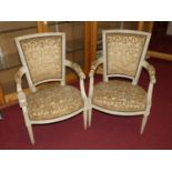 A pair of French cream painted upholstered and further studded fauteuils, in the Louis XVI taste,