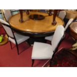 An Art Deco blond oak and ebonised circular dining table, raised on heavy reeded pedestal base to