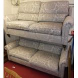 A pair of Duresta grey floral fabric decorated three-seater sofas, on turned supports to castors,