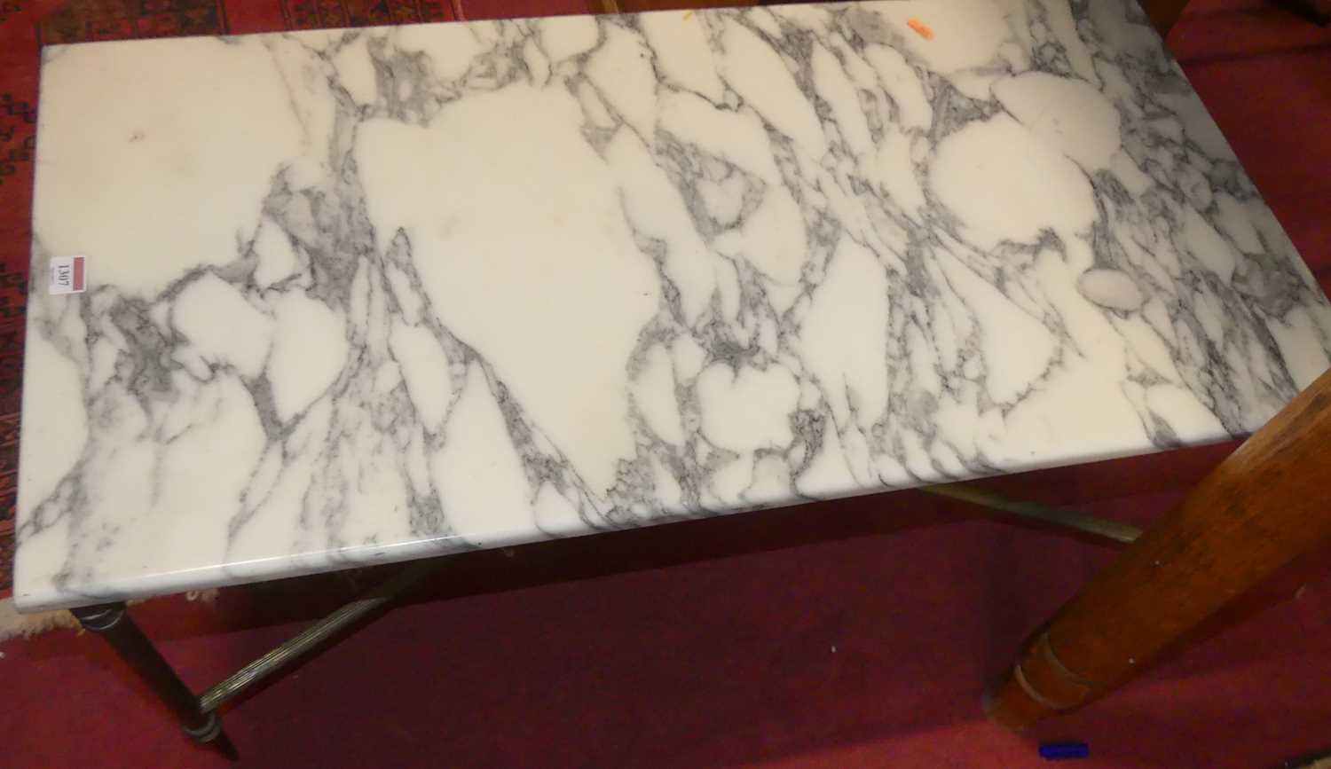 A variegated marble topped rectangular low coffee table, raised on reeded brass supports, length