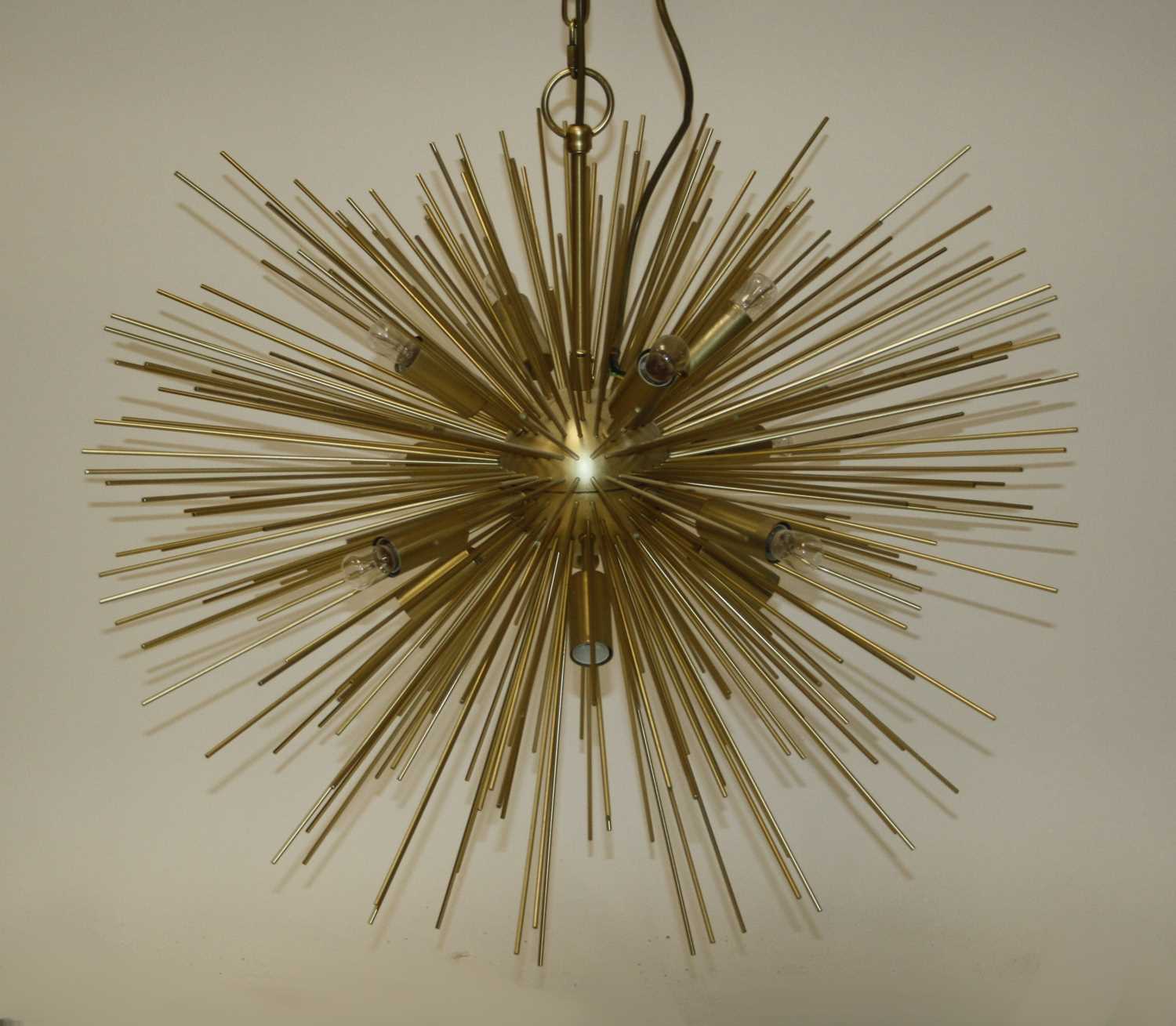 A contemporary gilt brass sunburst hanging ceiling light, having twelve baton lights surrounded by