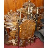 A Continental carved walnut heraldic wall mounted sword holder, the shield shaped centre holding
