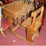 An early 20th century elm child's combination school desk/chair, having a slightly sloped hinged