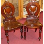 A pair of Victorian mahogany panelled seat hall chairs, on turned forelegs