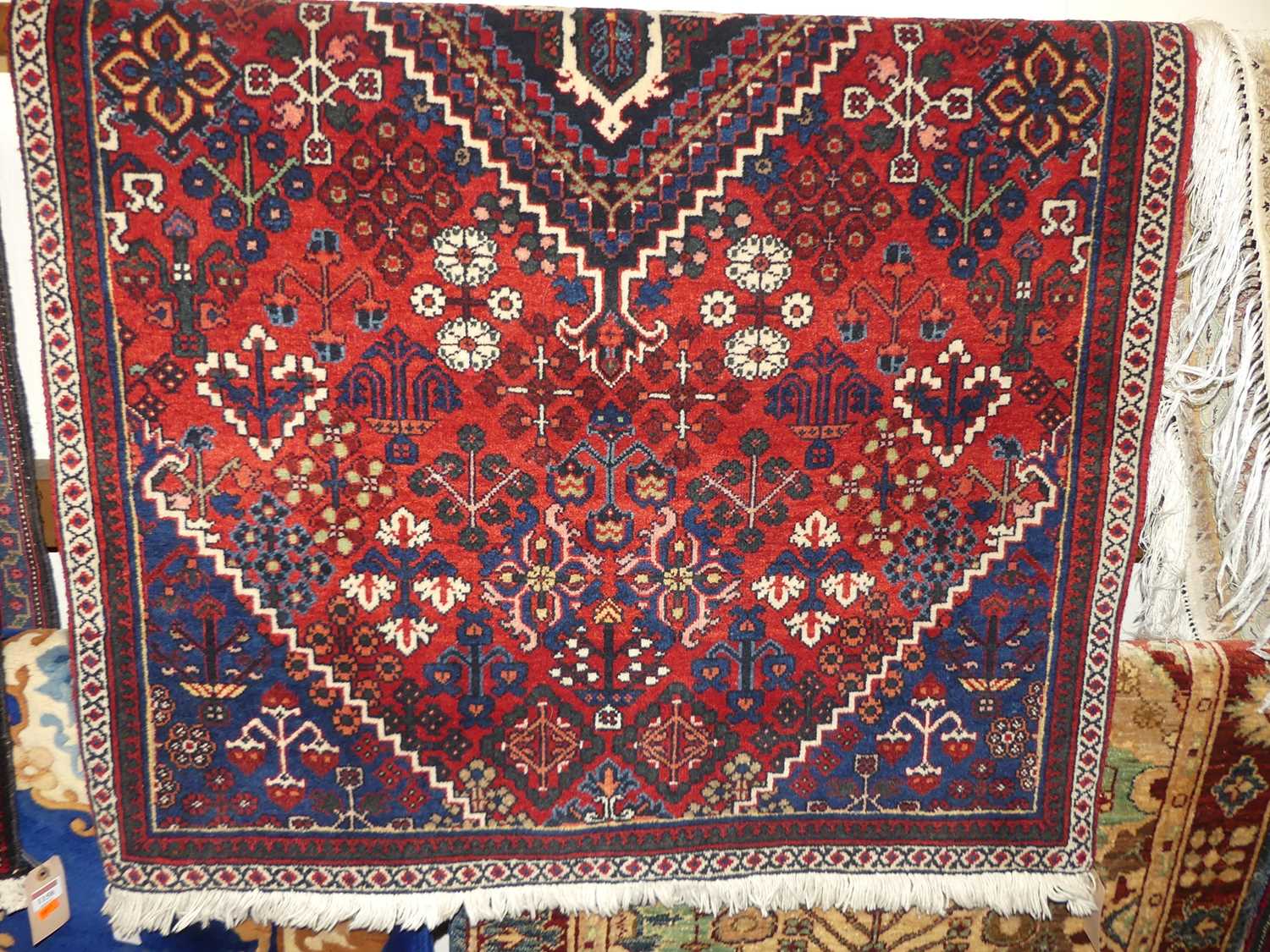 A Persian woollen red ground Tabriz rug, 185 x 103cm