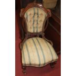 A mid-Victorian floral carved mahogany framed and striped buttoned upholstered nursing chair,
