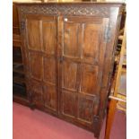 A joined oak double door panelled side cupboard, the interior converted into a wardrobe, width