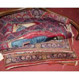 An Indian red ground rug, decorated with twin opposing seated figures, together with six further