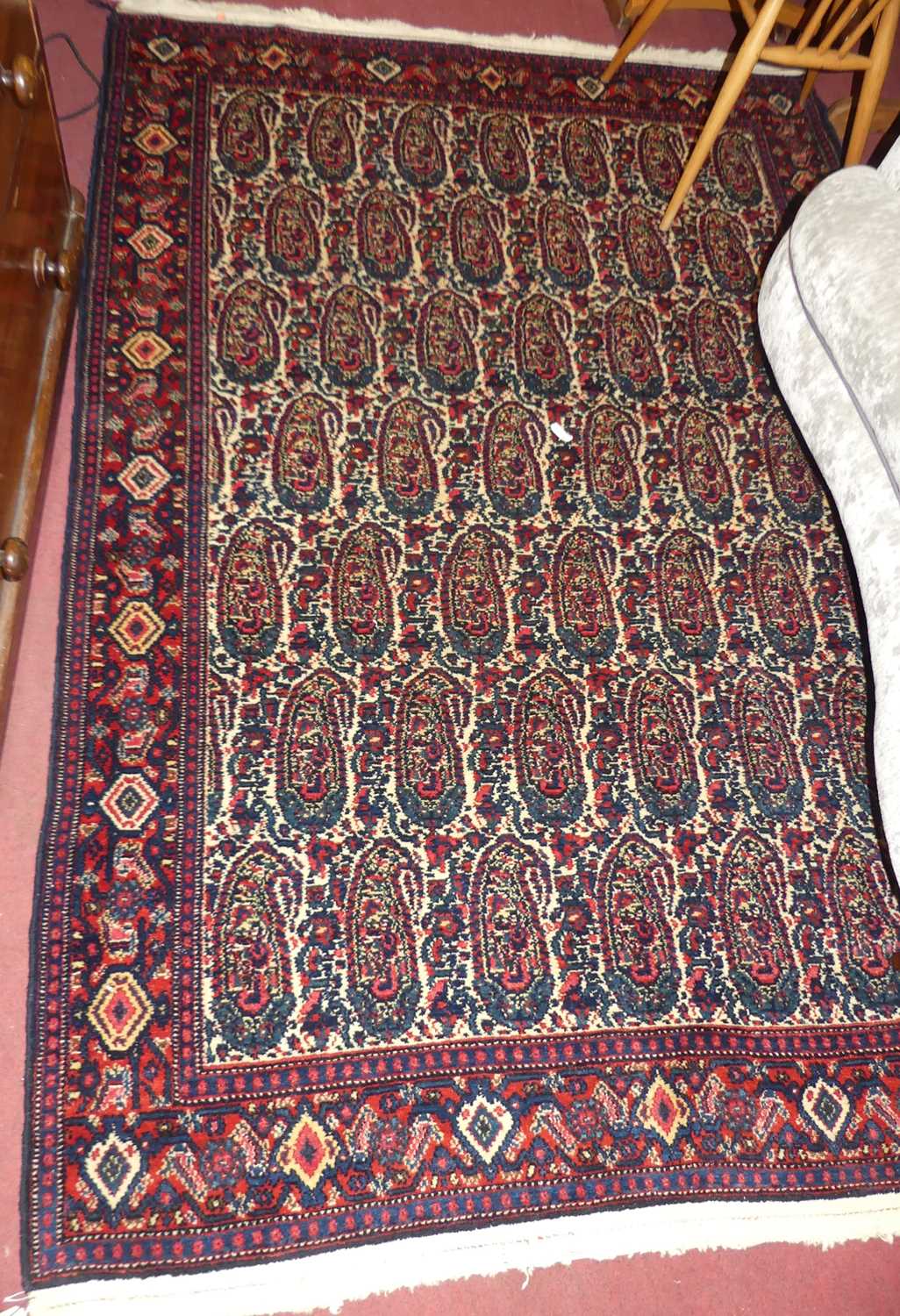 A Persian woollen red ground bokhara rug, having repeating central ground, 200 x 140cm