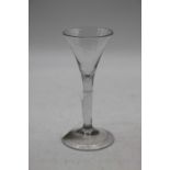 A liqueur glass in the mid 18th century style having a conical bowl on a plain stem and domed