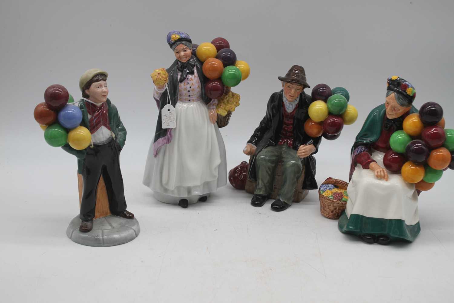 A collection of four Royal Doulton figures to include Balloon Boy, The Old Balloon Seller, Biddy