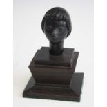 A small contemporary ebonised composition bust of a woman, of stylised form, with indistinct