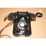 A vintage telephone, being wall-mounted and black enamelled