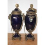 A pair of large table lamps, each on a deep blue ground with gilt metal mounts, with mask handles on