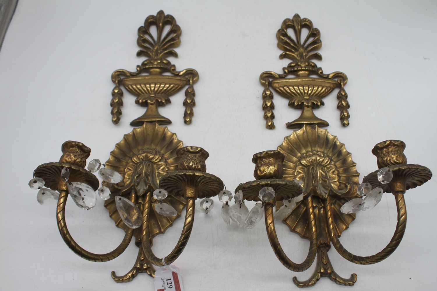 A pair of gilt brass twin sconce wall light fittings surmounted by an urn, height 47cm