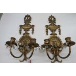 A pair of gilt brass twin sconce wall light fittings surmounted by an urn, height 47cm