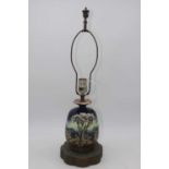 A tubelined pottery oil lamp on pierced brass stepped base, height 61cm (including fittings)