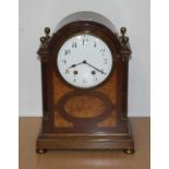 An early 20th century mahogany cased mantel clock, the enamelled dial showing Arabic numerals,