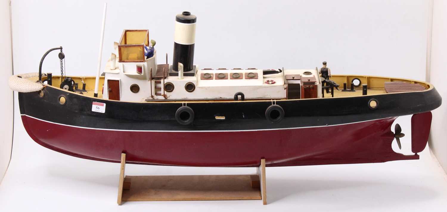 A wooden kit built model of a radio controlled tug boat, hand painted in maroon and black with