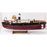 A wooden kit built model of a radio controlled tug boat, hand painted in maroon and black with