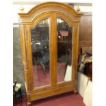 A large contemporary French walnut arched twin mirrored door armoire by And So To Bed, with fluted