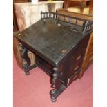A black painted slopefront davenport, having three typical side drawers and raised gallery back, w.