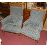 A pair of late Victorian oak framed lady's and gent's parlour chairs, having blue fleur de lys