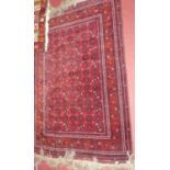 A Persian woollen red ground Bokhara rug, having tasselled ends, 178 x 117cm