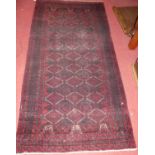 A Persian woollen red ground Bokhara rug, 213 x 110cm