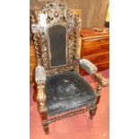 A late 19th century heavily carved parlour armchair, having studded upholstered pad back, seat and