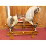 A Victorian dapple-grey child's rocking horse, having a tan leather and brass studded saddle and
