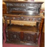 A late 19th century heavily carved oak buffet side cupboard, having raised superstructure, twin