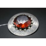 A Scottish style silver and amber quartz set brooch, having bright cut engraved thistle