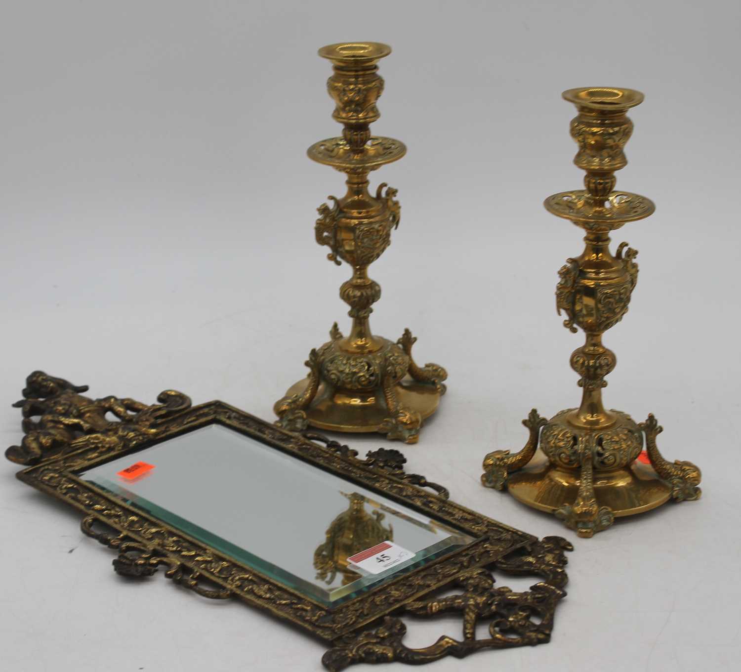 A pair of 19th century brass table candlesticks, h.23cm; together with a brass wall mirror, 43 x